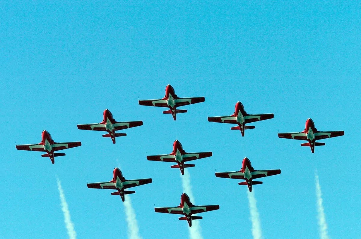 A formation of red and white Canadian Forces Snowbirds CT-114 Tutor jets in flight