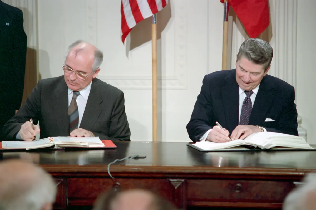 Two heads of state signing a treaty document at a formal ceremony