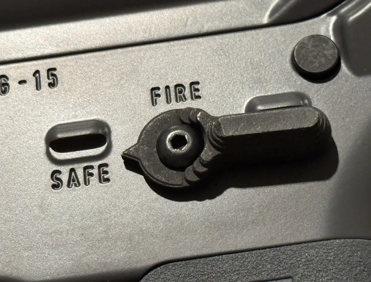 Close-up of an M16 rifle selector switch marked safe semi and burst